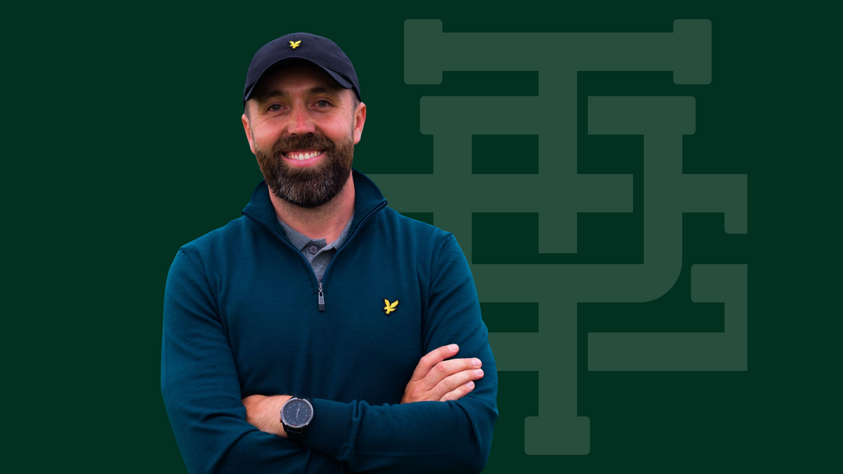Smiling golfer in a navy Lyle & Scott quarter-zip and cap with the golden eagle logo, on a Three Putt Golf monogram backdrop