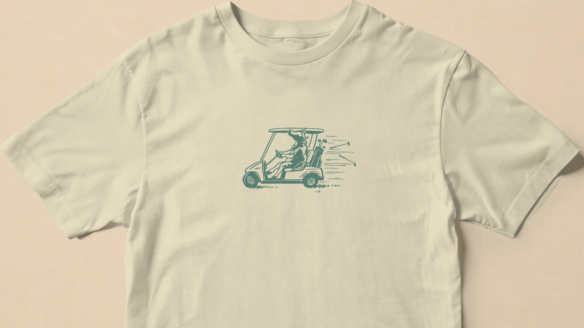 Reckless Driving golf T-shirt in Cream laid flat, printed with a cow speeding in a golf cart