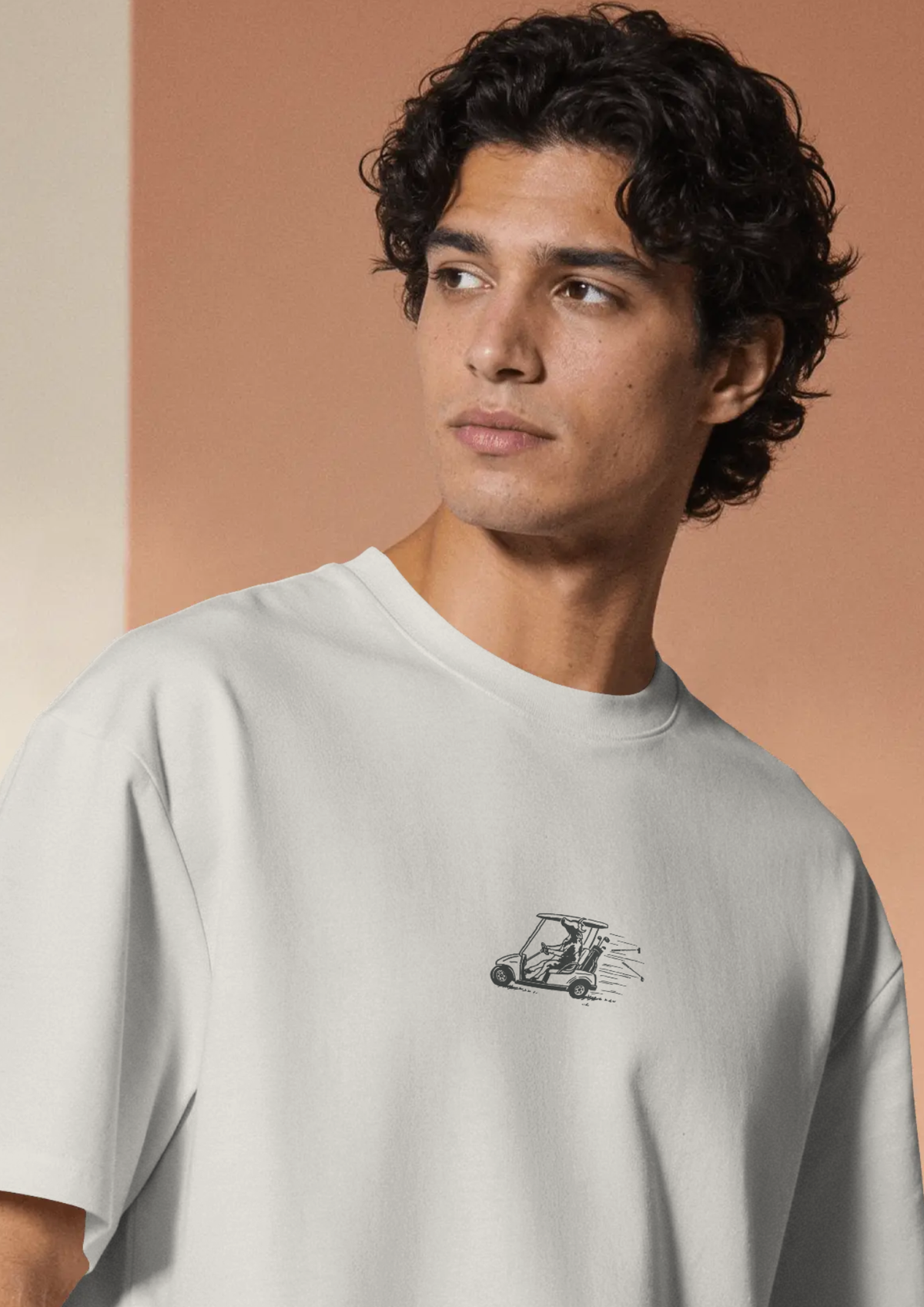 Man wearing the Reckless Driving golf T-shirt in White, with the cow-and-golf-cart print on the chest