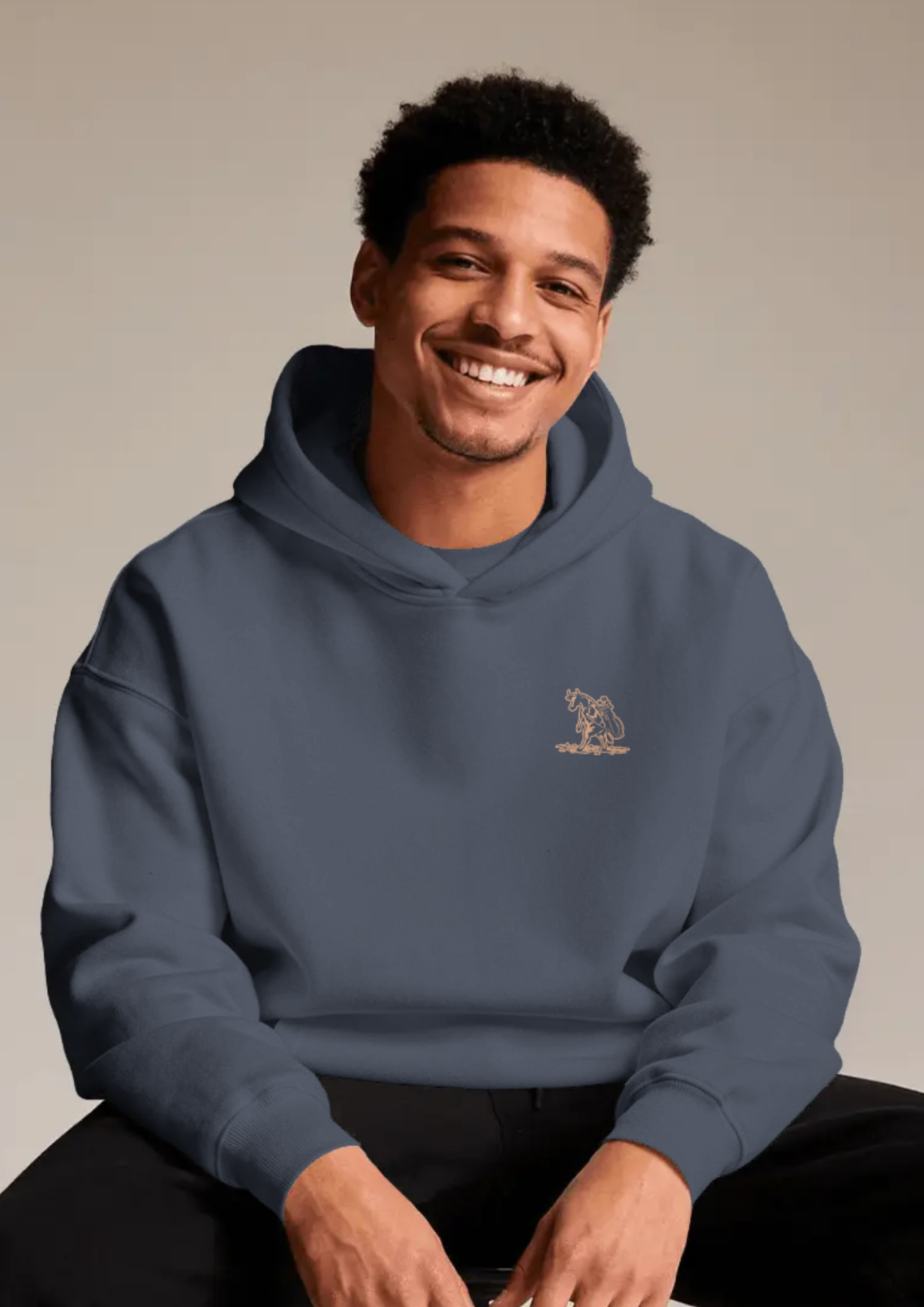 Smiling man wearing The Scenic Route golf hoodie in Navy, with the cow-and-golf-bag chest print
