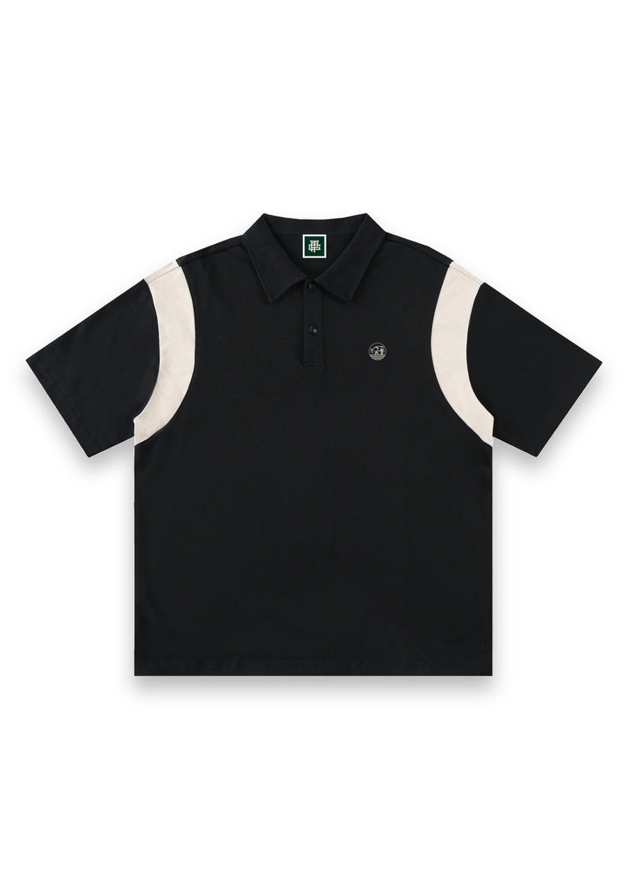 Dogleg cotton golf polo shirt in Black with Cream, front view with cream shoulder panels and the round Three Putt cow badge on the chest #Colour_Black with Cream
