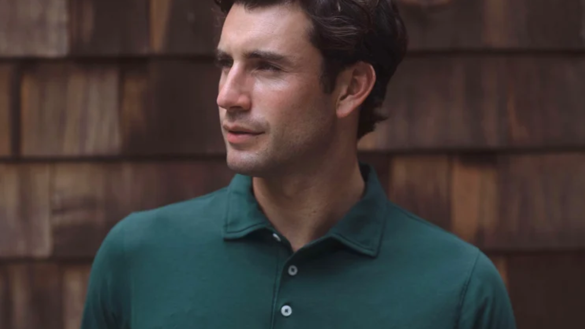 Model in a dark green B.Draddy cotton polo shirt