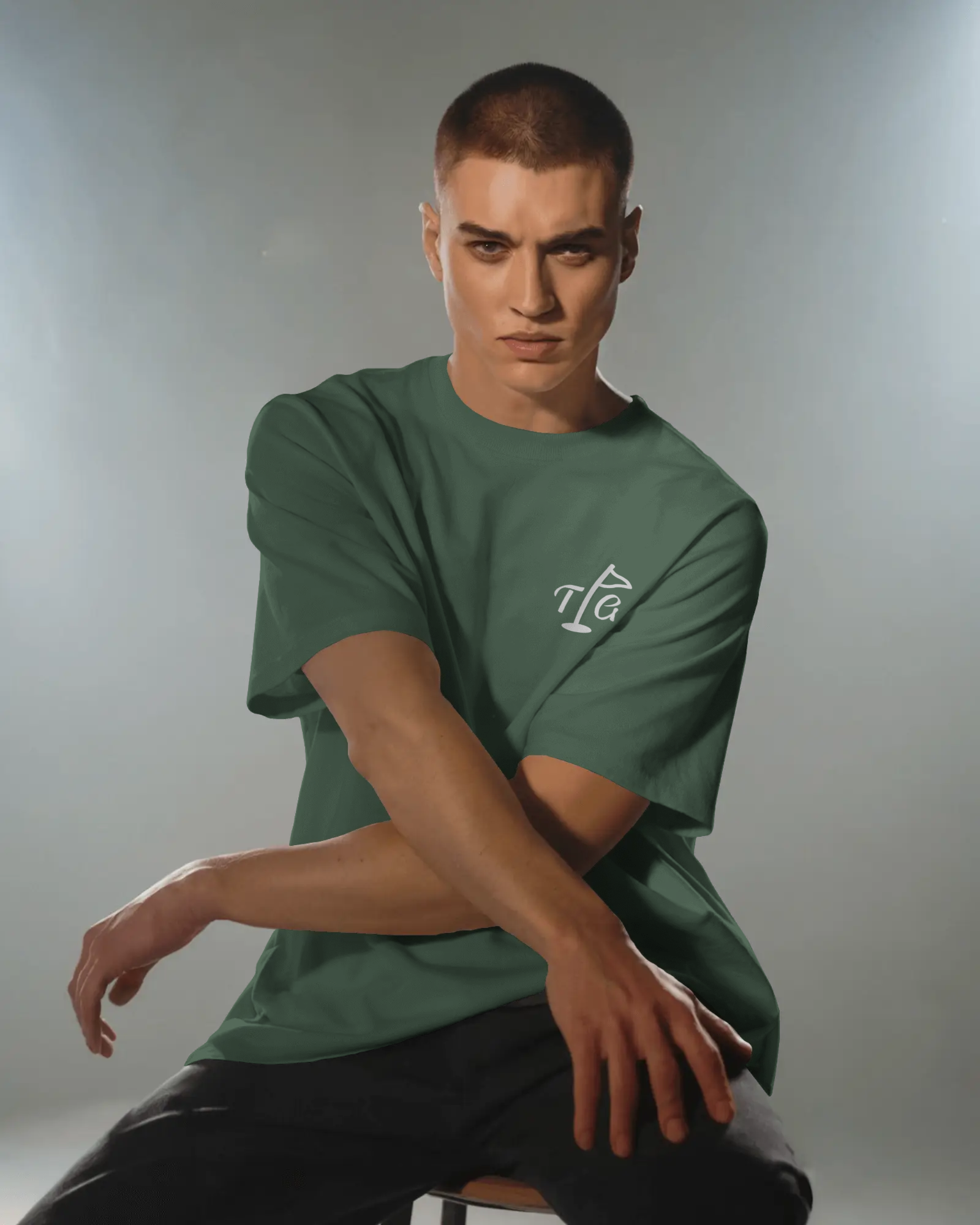 Male model seated in Three Putt Golf Streetwear T-Shirt in Green, relaxed fit